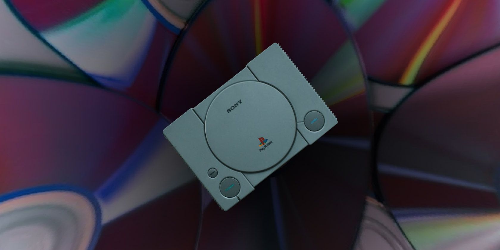 An image of an original PlayStation console layered over CDs