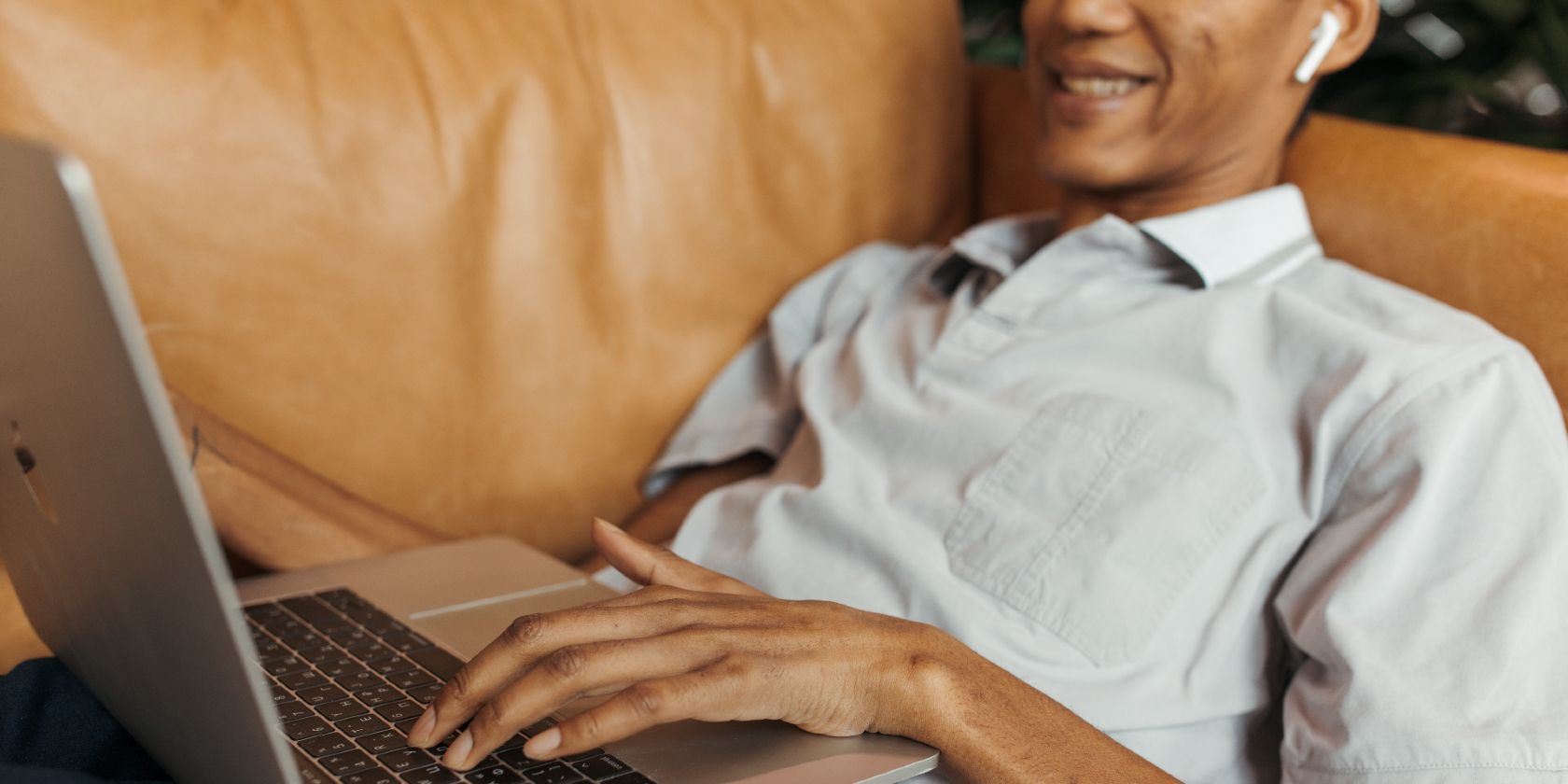 Man Lying on the Couch Typing on Laptop