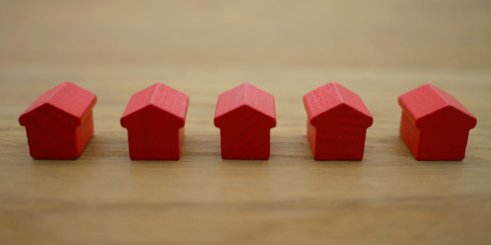 linha de pequenos blocos de madeira vermelhos em forma de casas