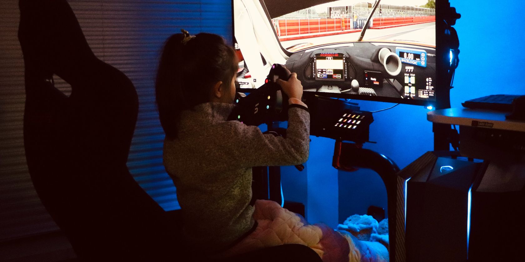 Little girl sitting in a racing sim