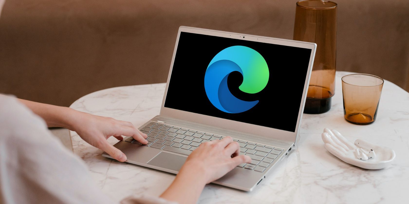 Women using a laptop with Microsoft Edge logo on screen. 