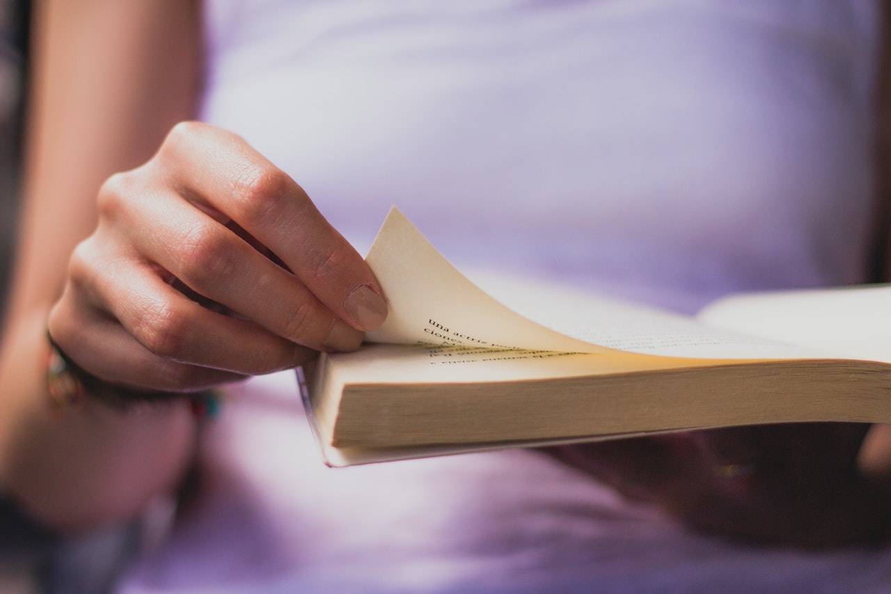 Person flipping a page of a book