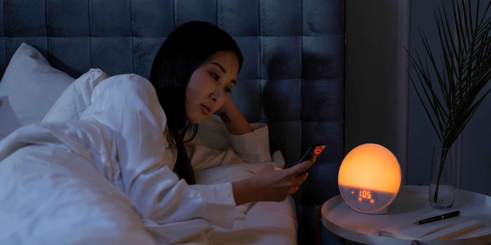 person using phone in bed nighttime
