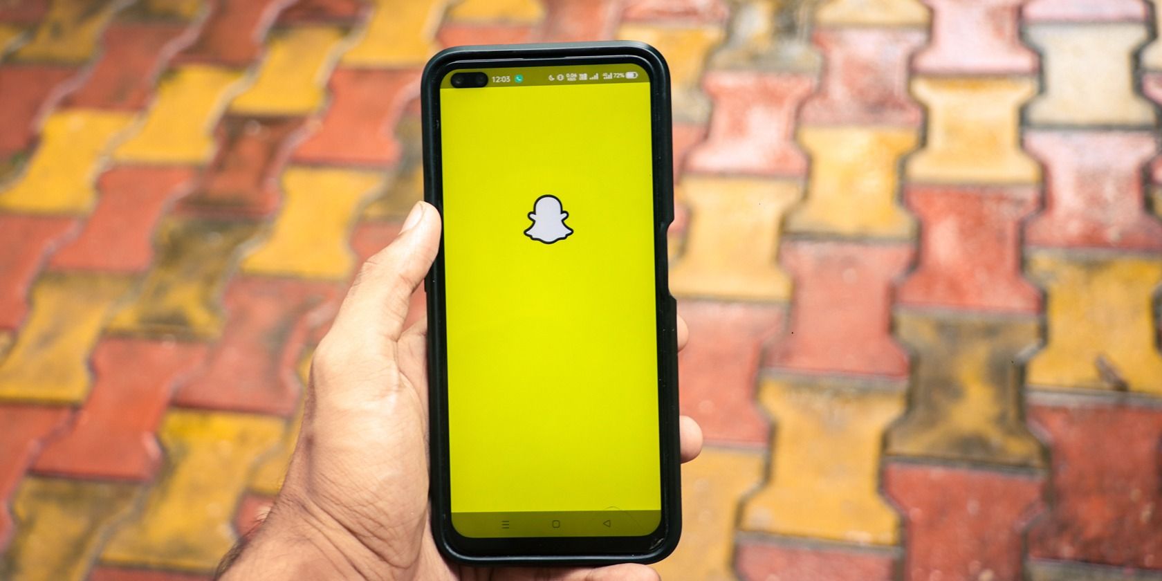 man holding phone with snapchat open