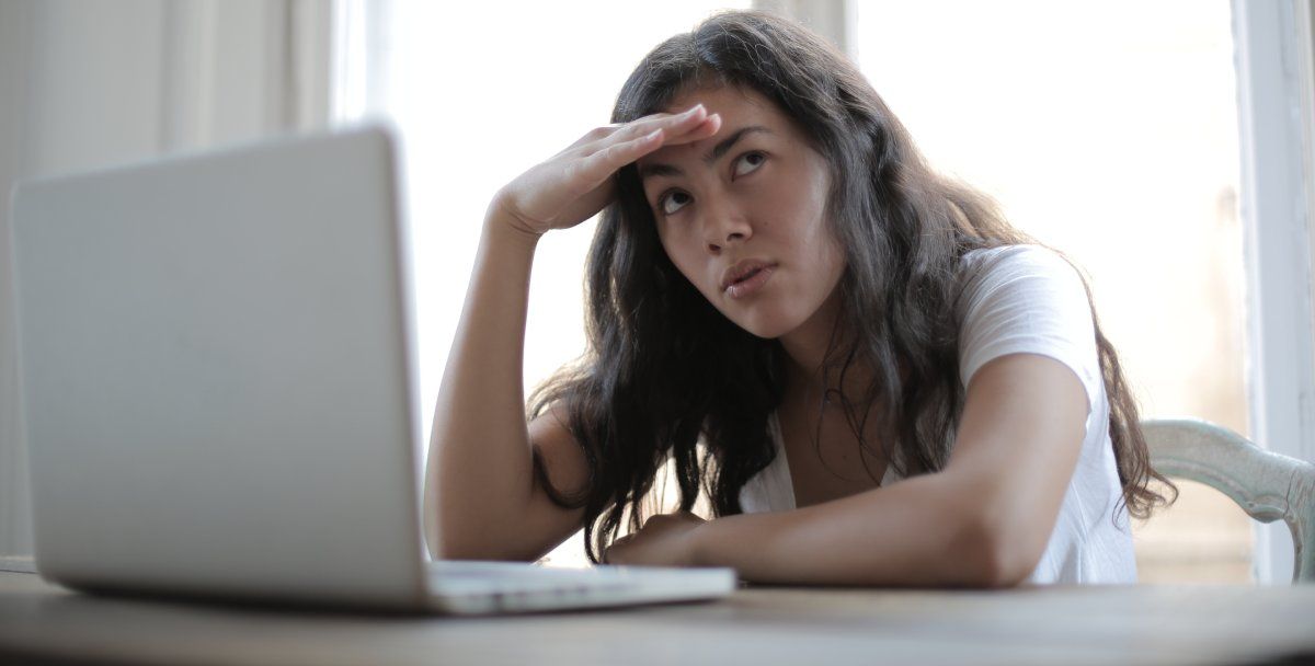 Jovem freelancer irritada usando laptop em casa