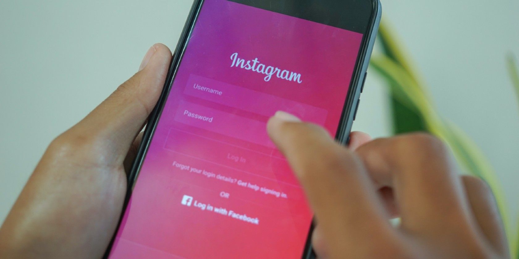 Person holding a phone showing the Instagram app login screen.