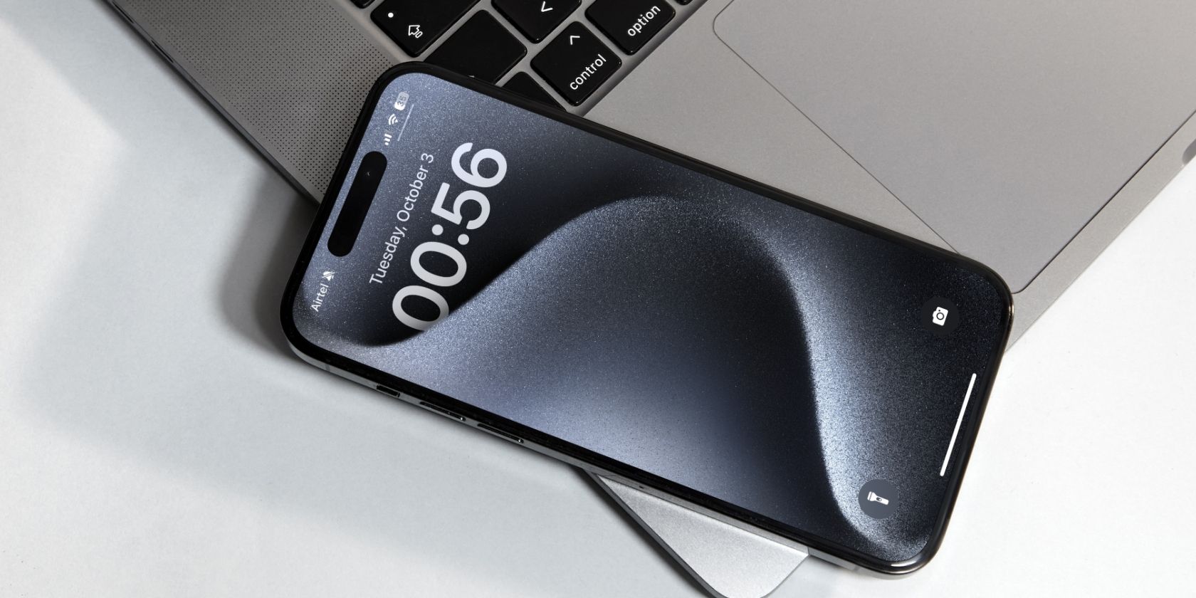 An iPhone showcasing it's lock screen while kept on a laptop