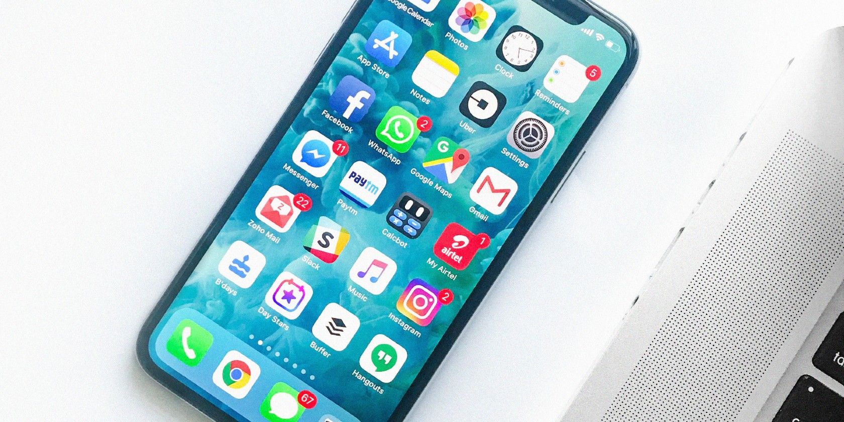 An unlocked iPhone showing the home screen laying on a white table.