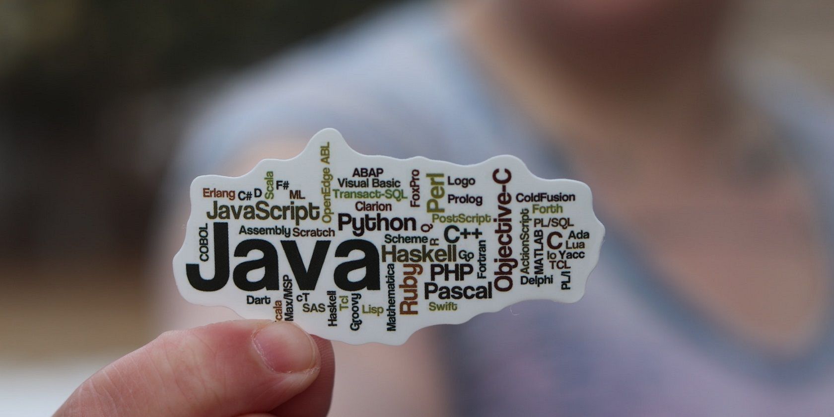 A person holding paper with Java text on it