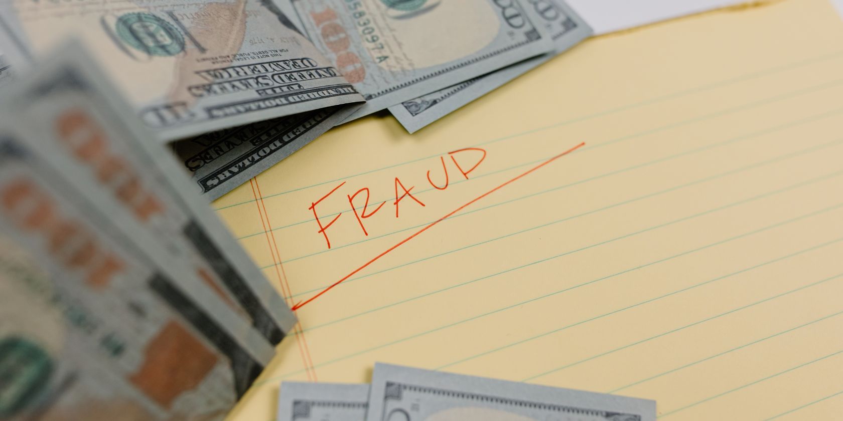 Money surrounds the word fraud in red letters