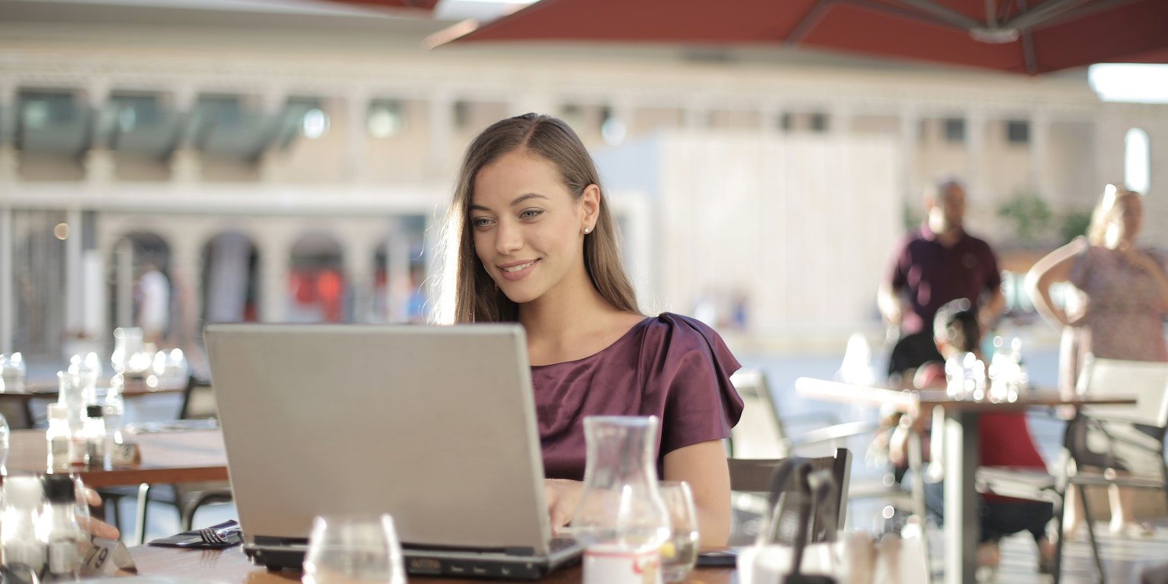 smiling woman in a restaurant using her laptop