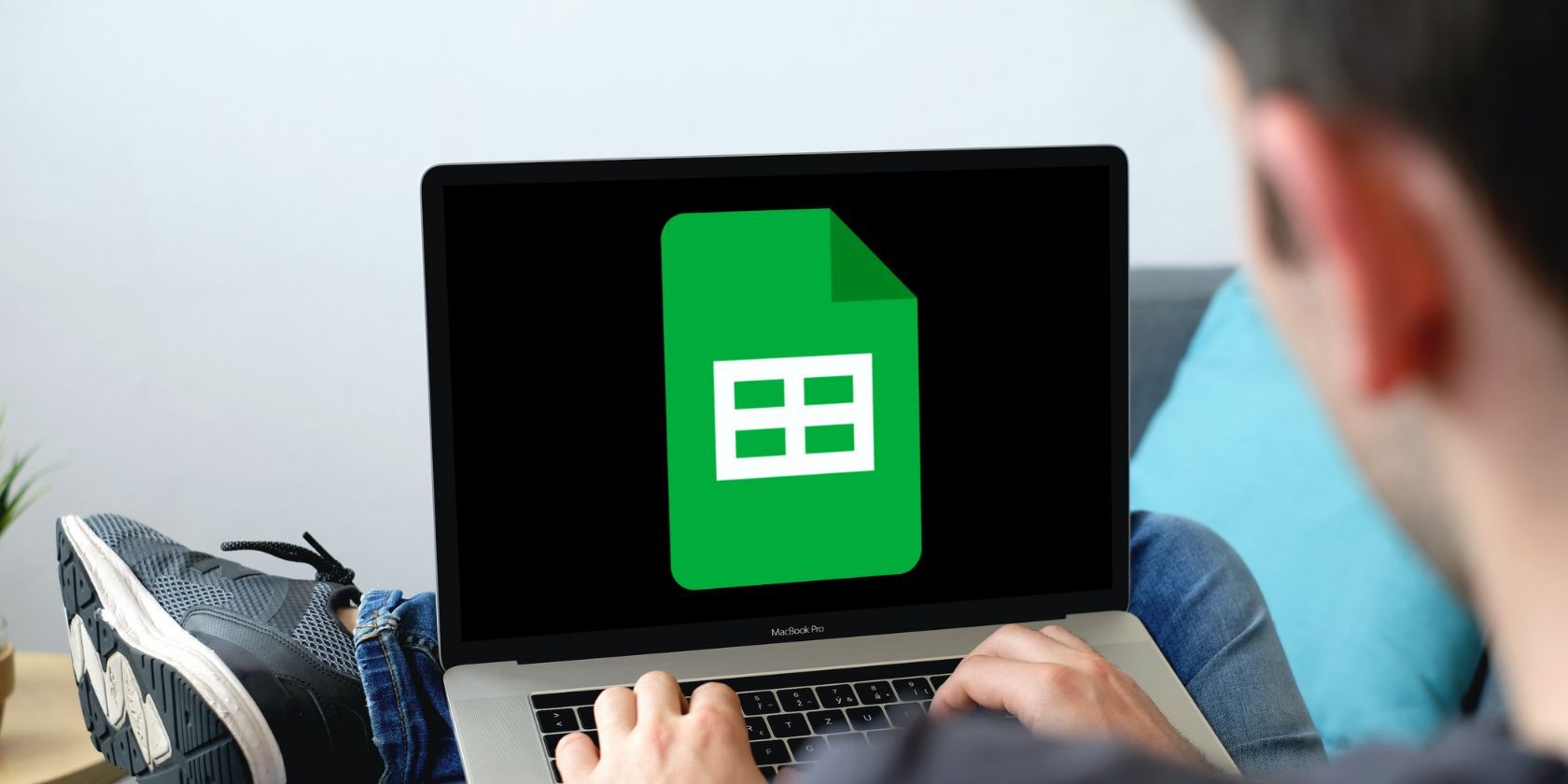 Male working on a laptop with Google Sheets logo on screen. 