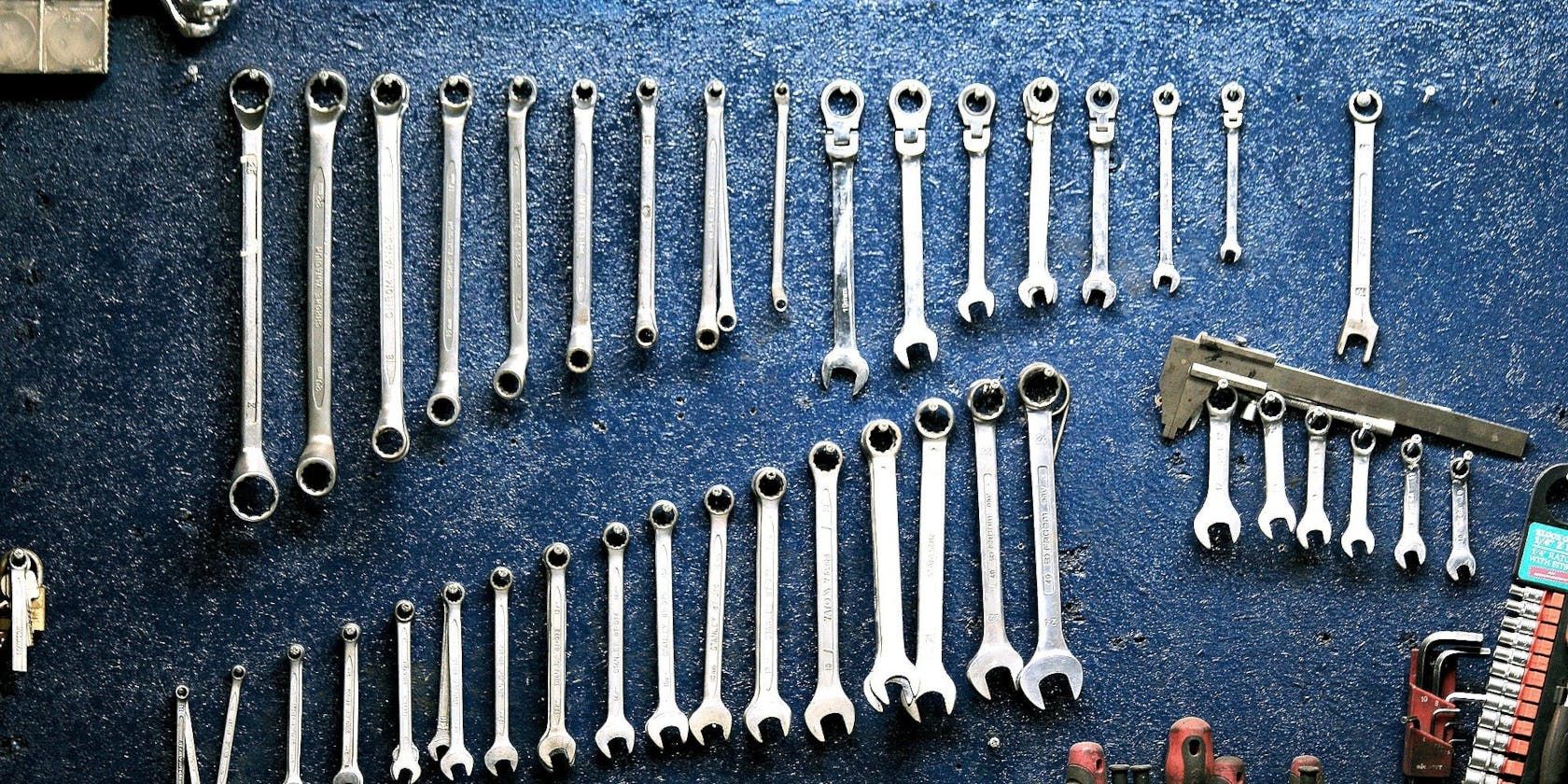 Different-sized wrenches hanging on a wall.