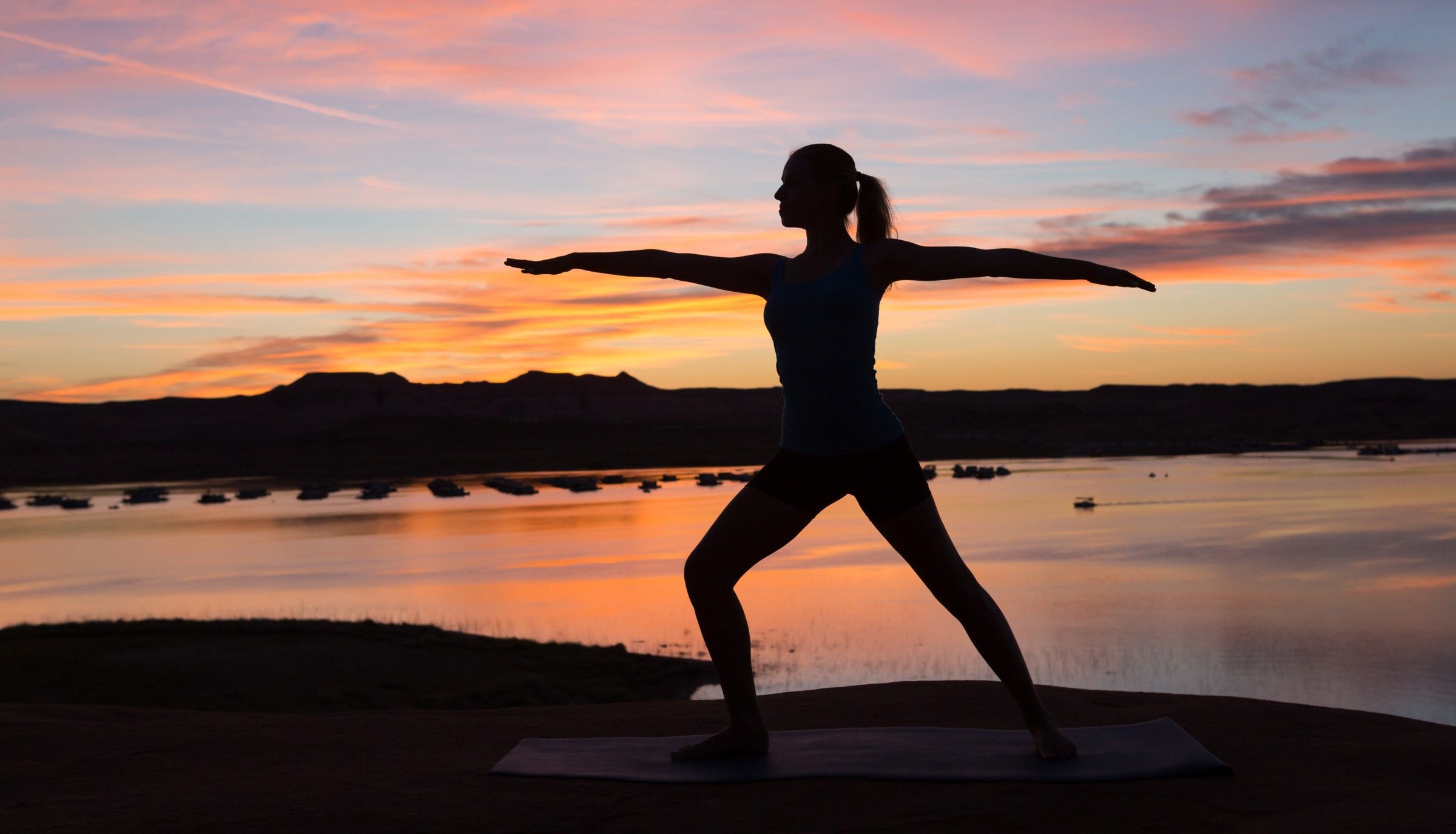 woman doing a yoga pose outside at sunset