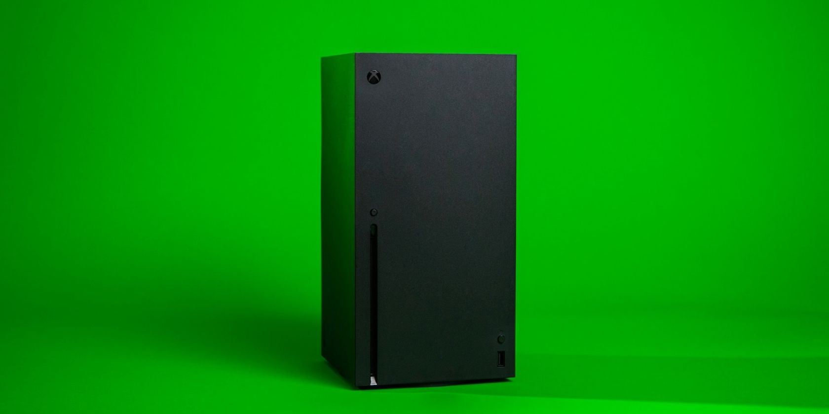 A photograph of an Xbox Series X console in front of a green screen