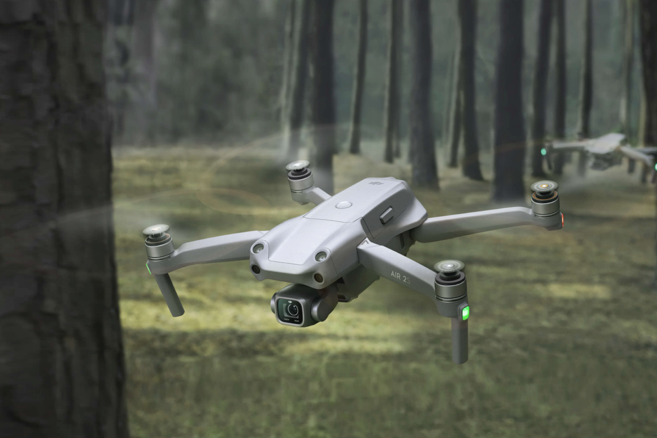 Deux drones DJI Air 2S manœuvrant dans une forêt.