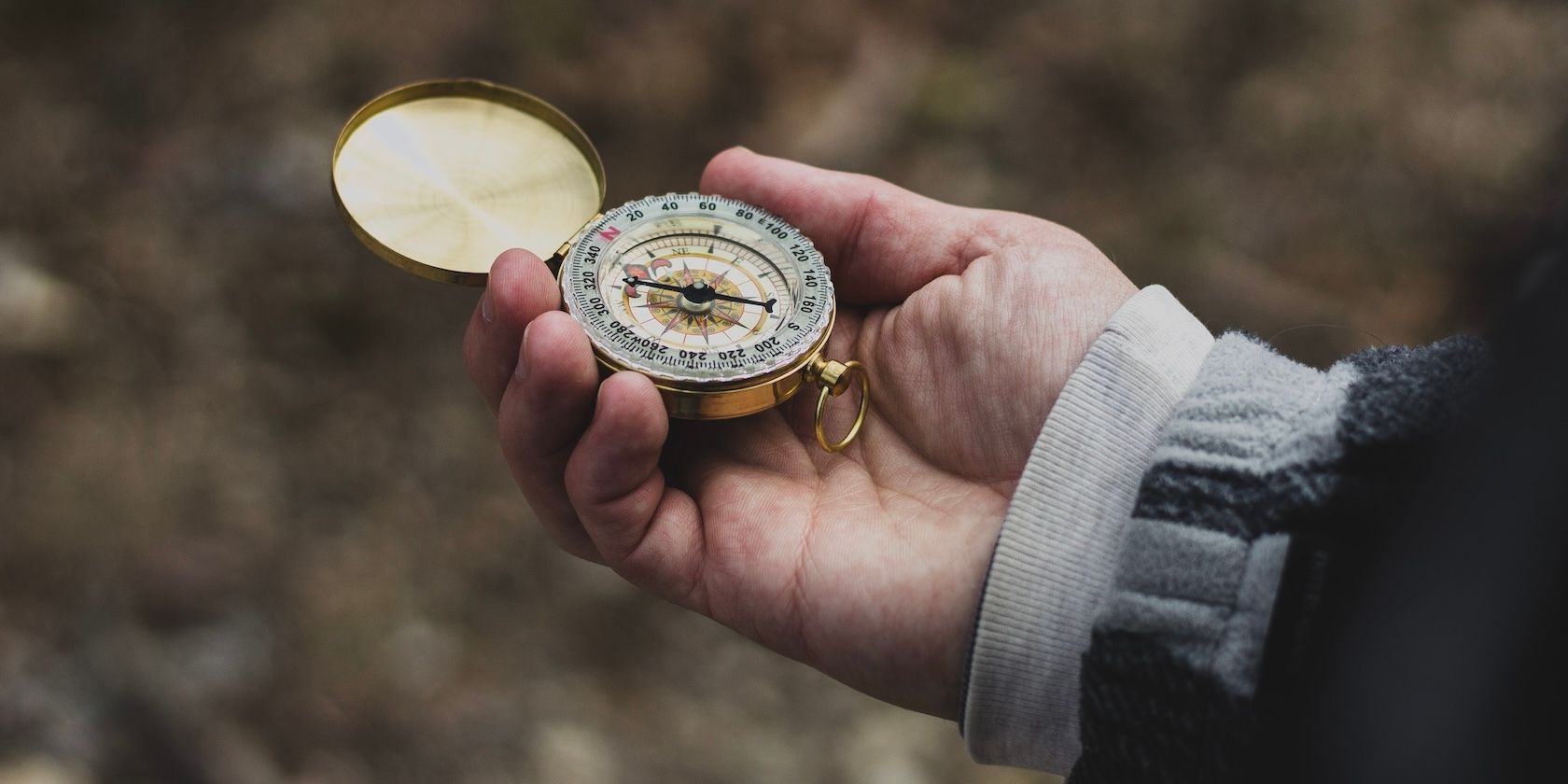 hand holding compass outdoors