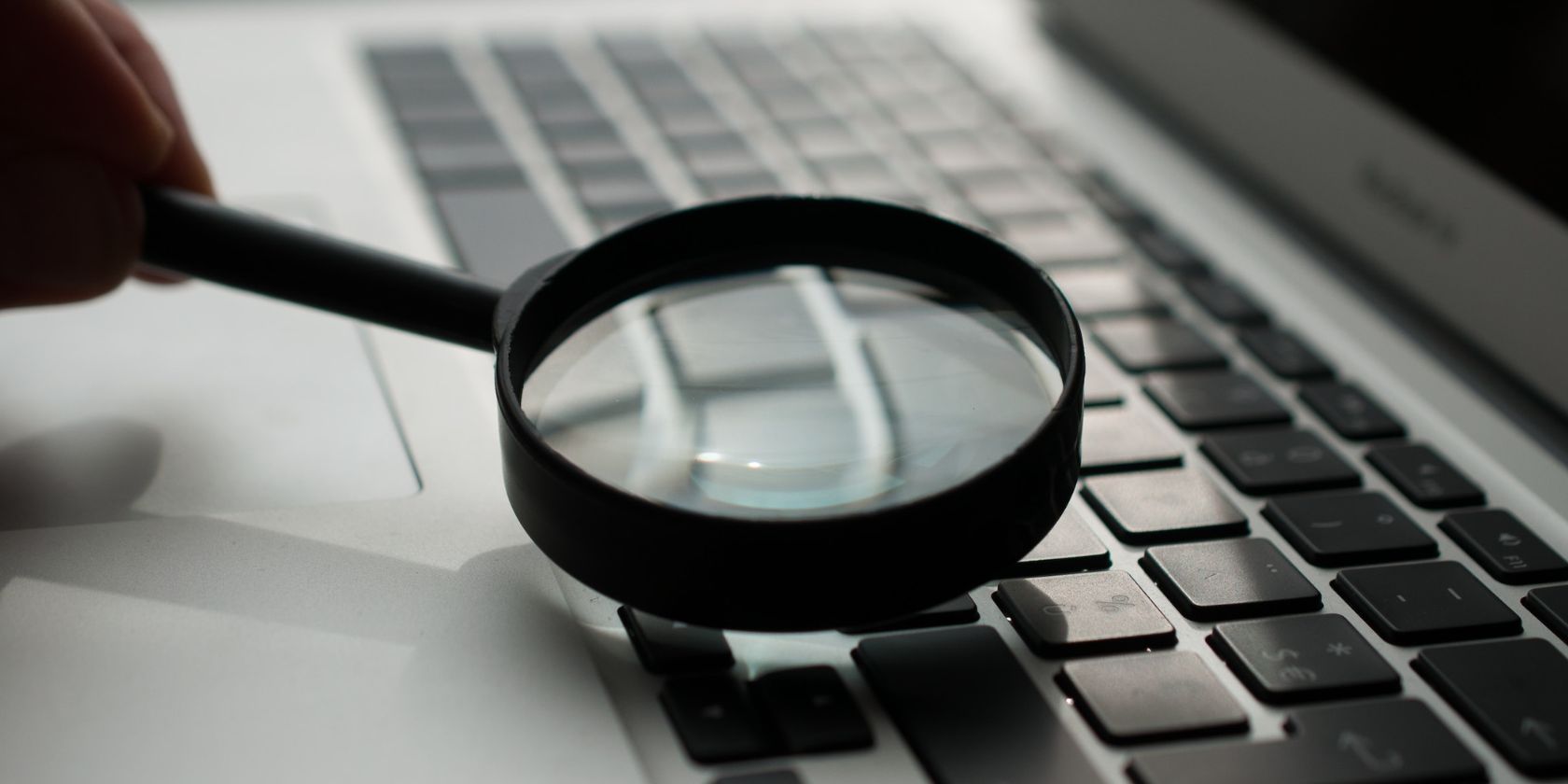image of magnifying glass above laptop keyboard