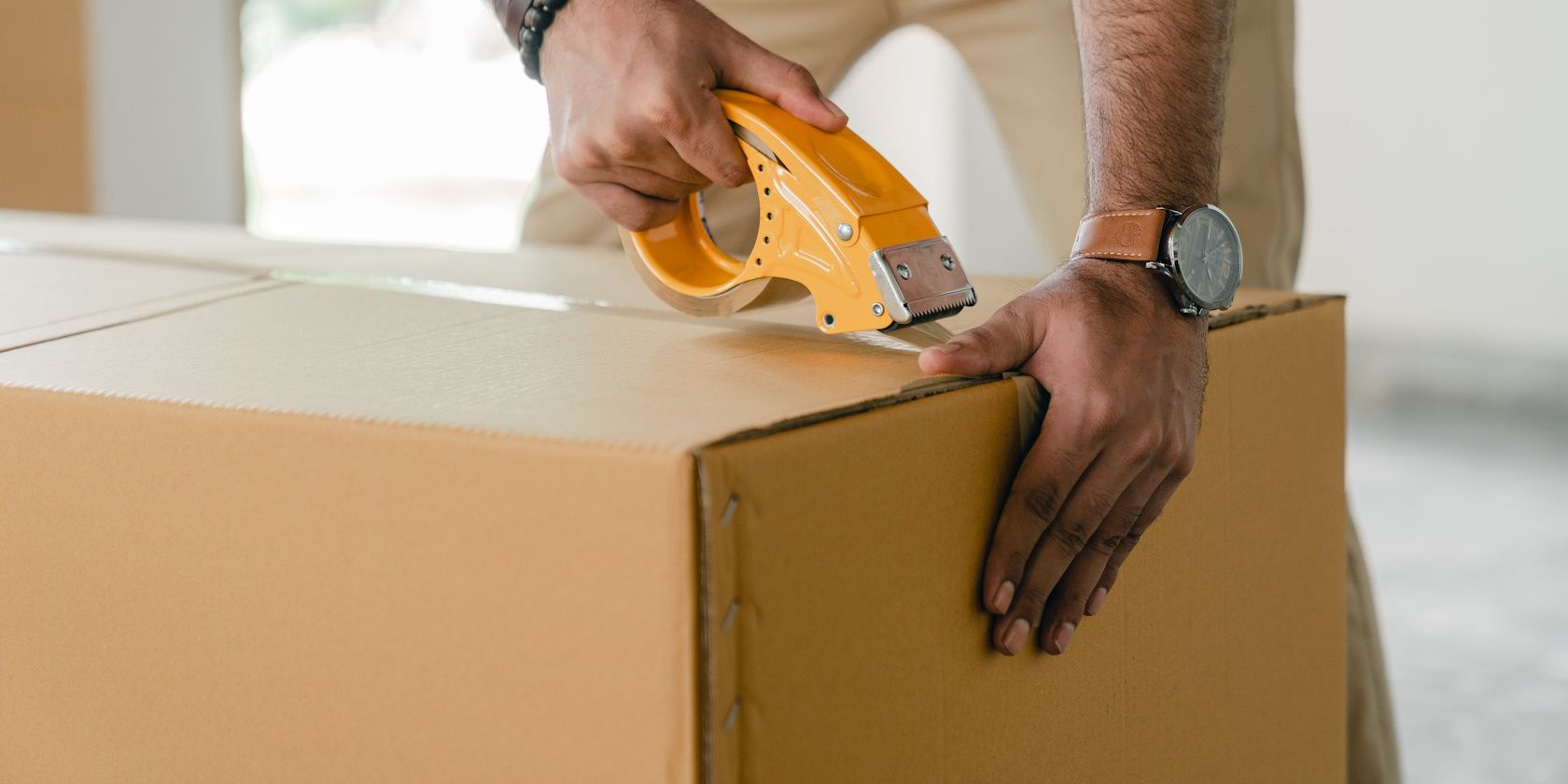 close-up of person holding and taping package for delivery