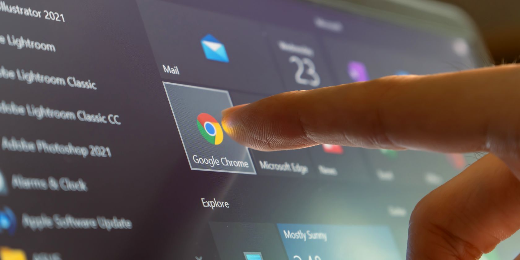 person pressing google chrome logo on touchscreen device