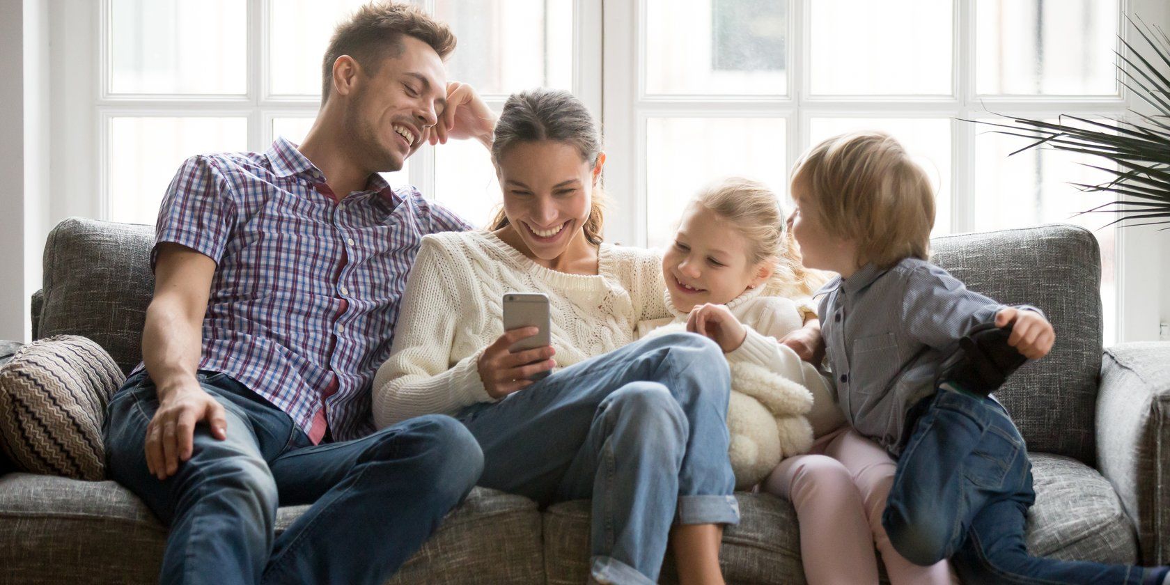family on sofa looking at phone