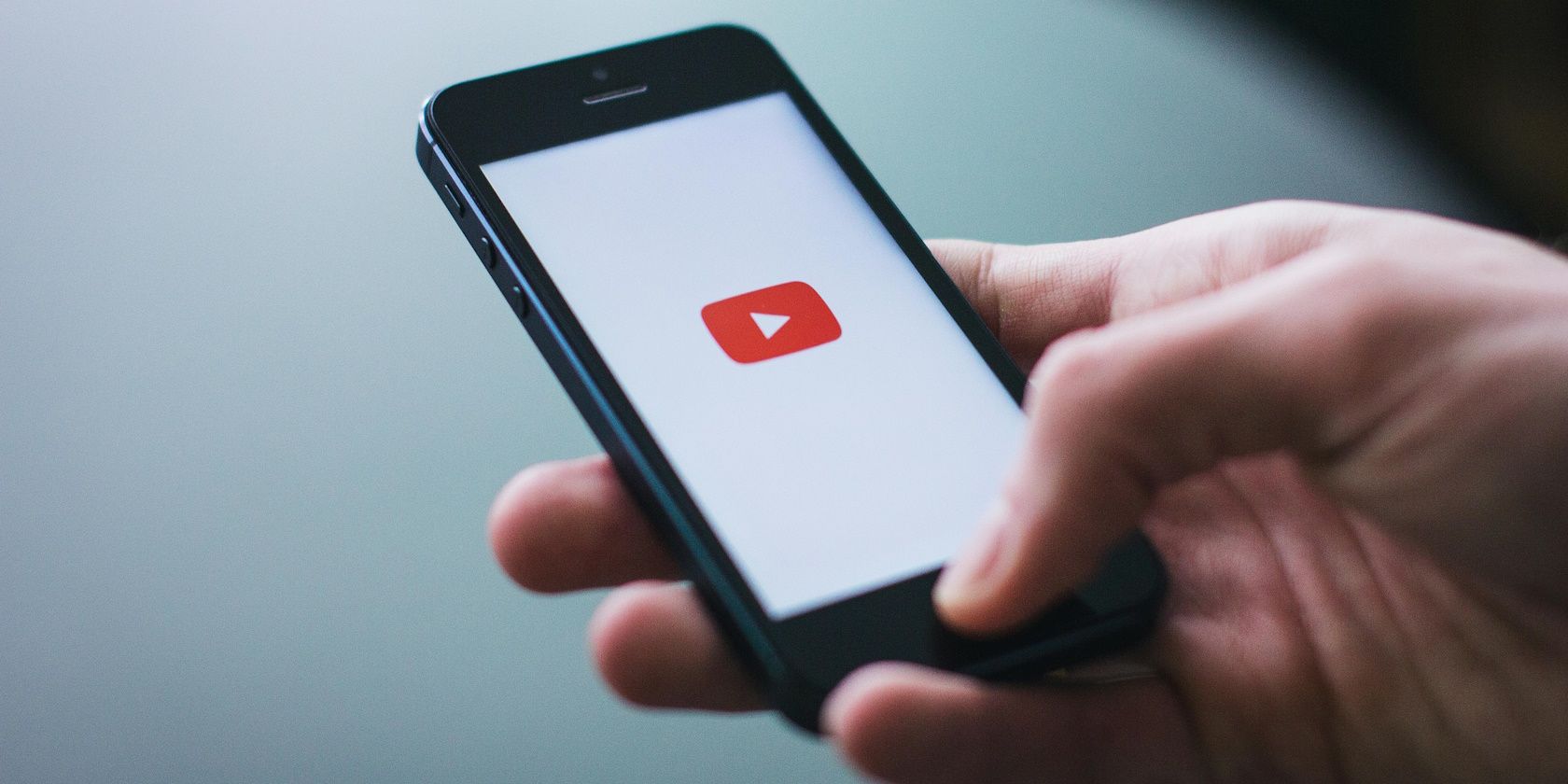 person holding smartphone while using YouTube app