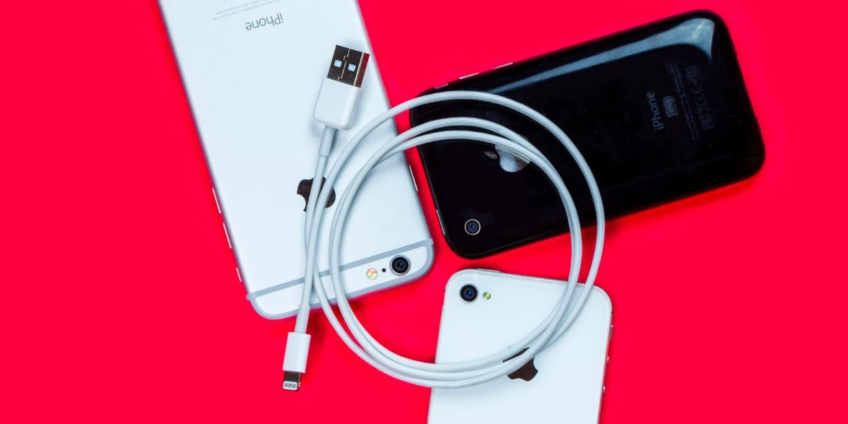 white lightning to usb-a cable on top of three iphones 