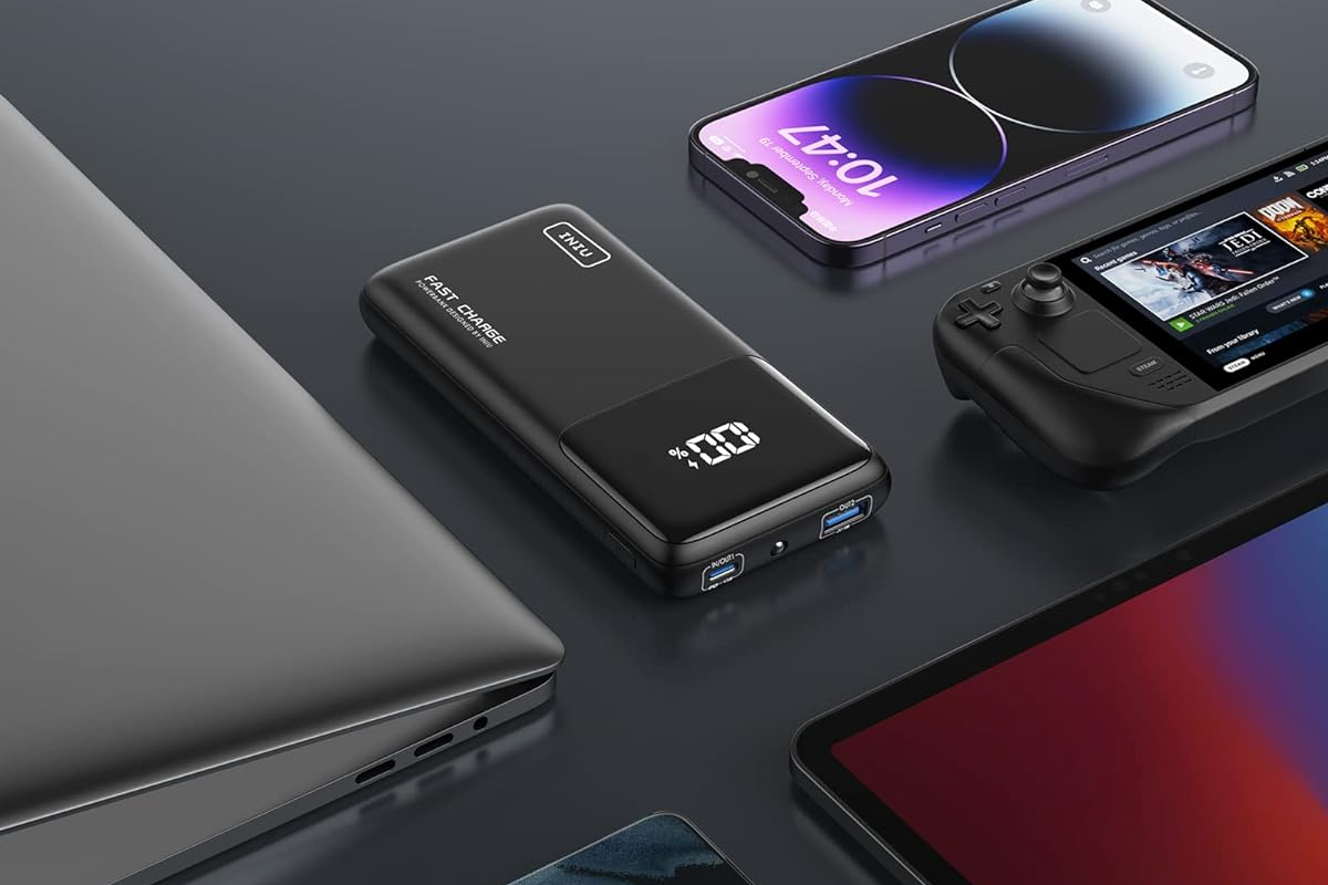 iniu portable charger alongside devices and a steam deck