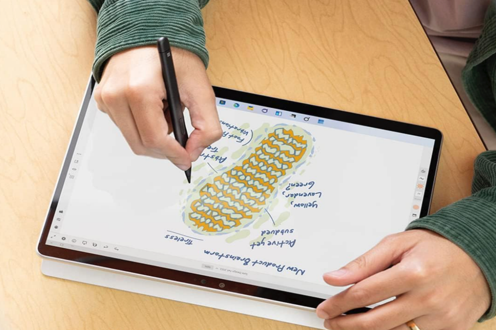 A man adding notes to a sketch on the Microsoft Surface Pro 9 tablet.