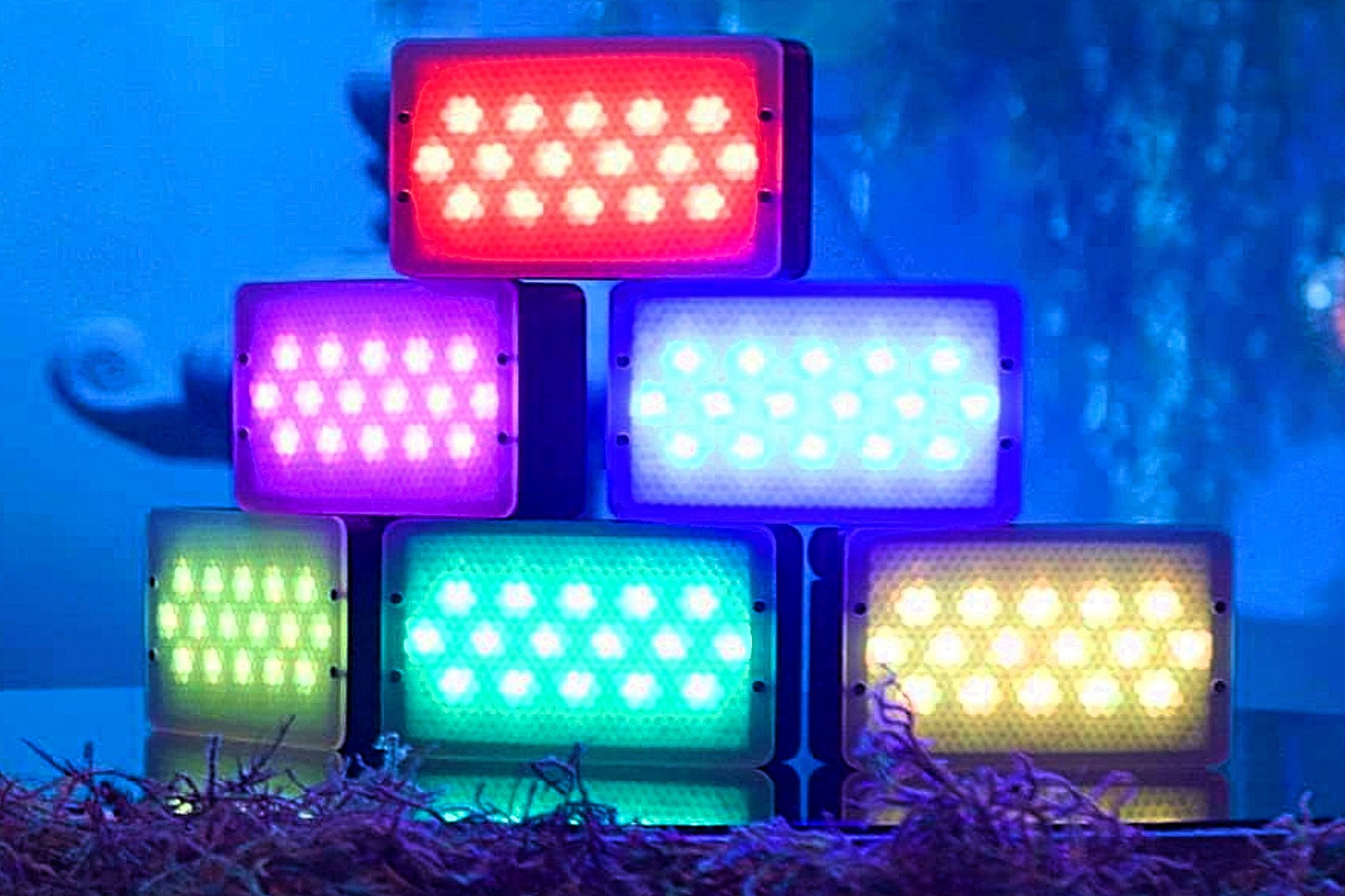 Several Aputure MC Pro lights built on top of each other and displaying different colors.
