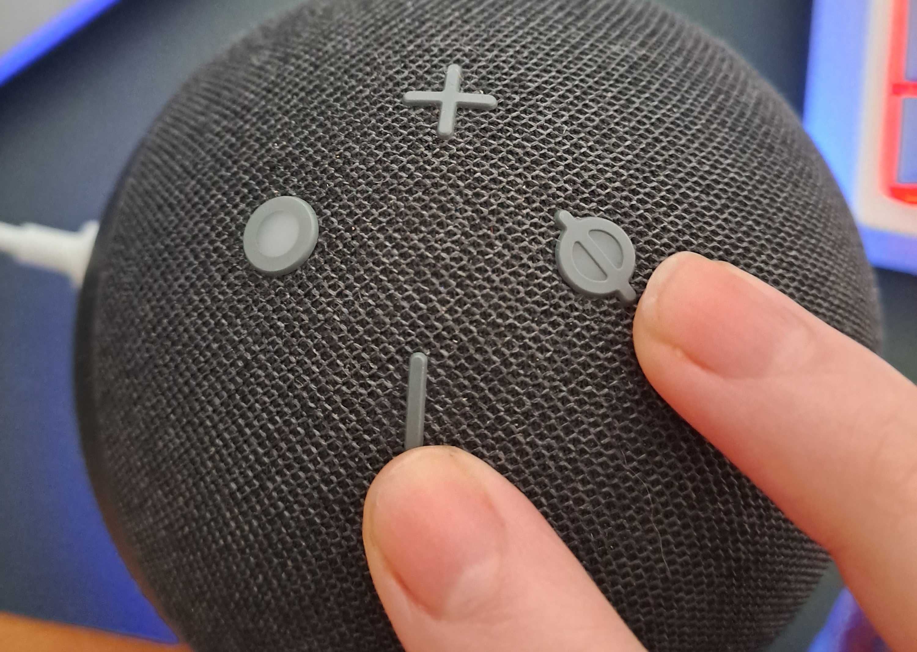 close up shot of Amazon Echo buttons with fingers pointing to volume down and microphone off