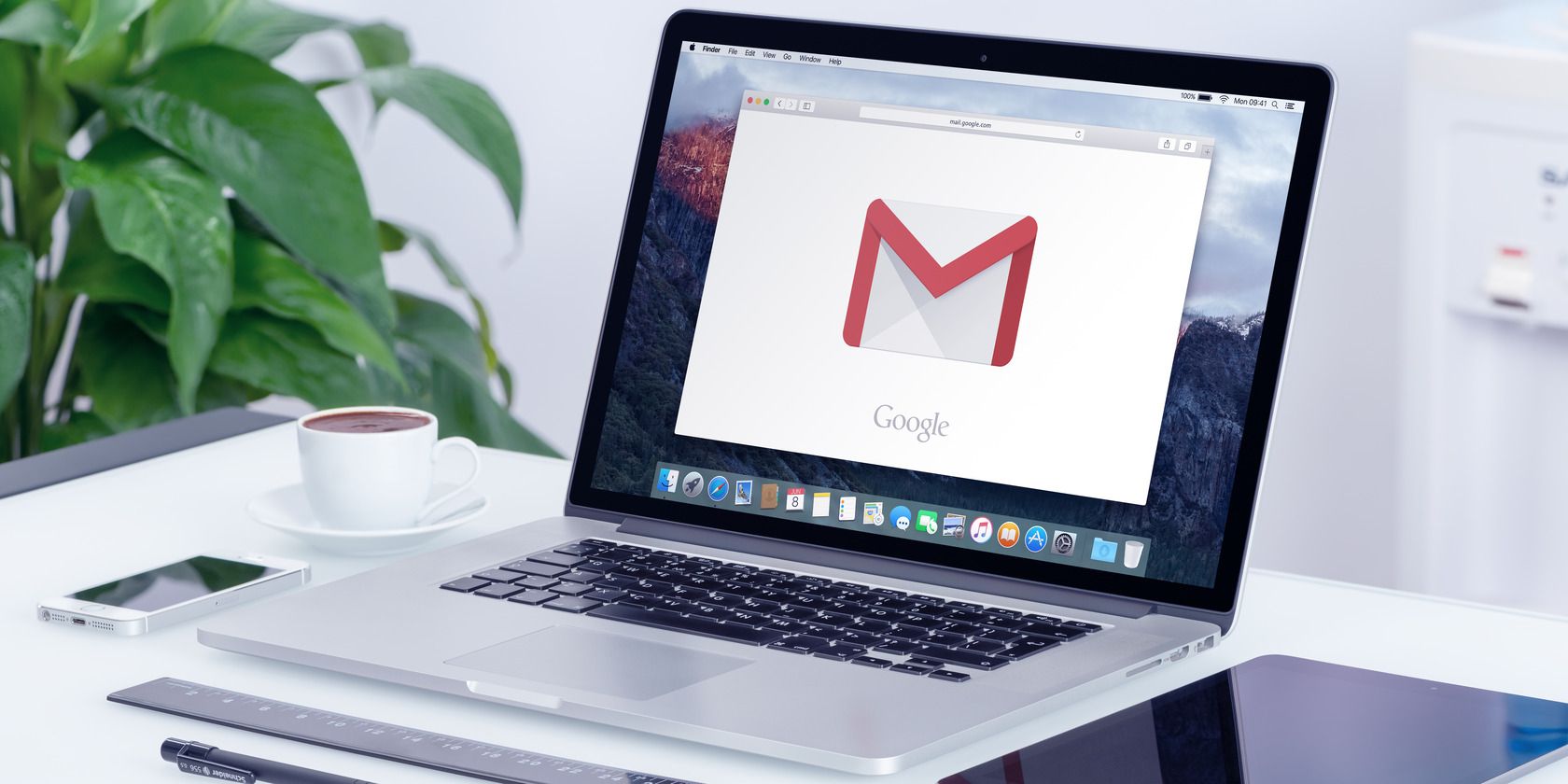 Google Gmail logo on the Apple MacBook Pro display that is on office desk in modern office work place