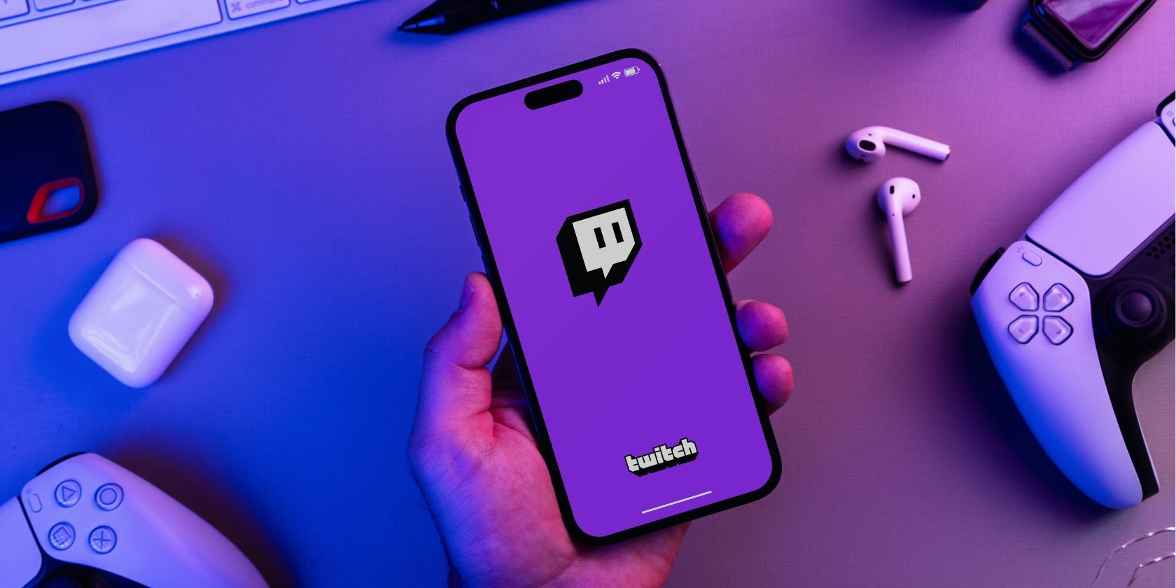 Man holding an iPhone 14 Pro smartphone with Twitch app