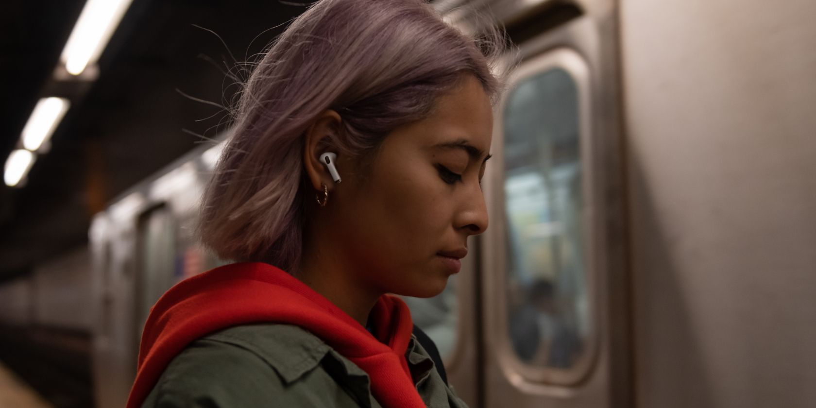 person wearing AirPods Pro on a subway