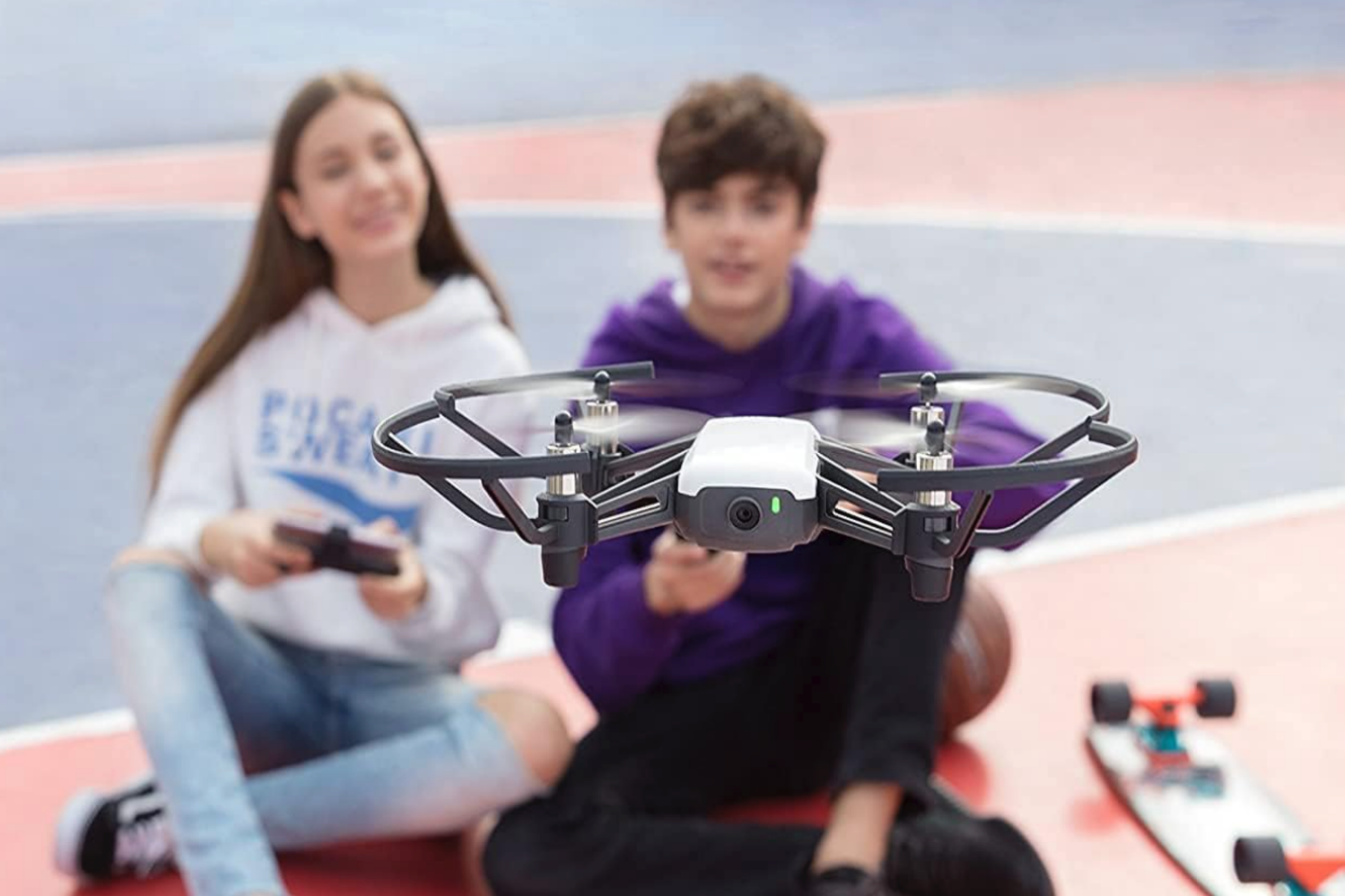 Two children flying a Ryze Tech Tello mini drone.