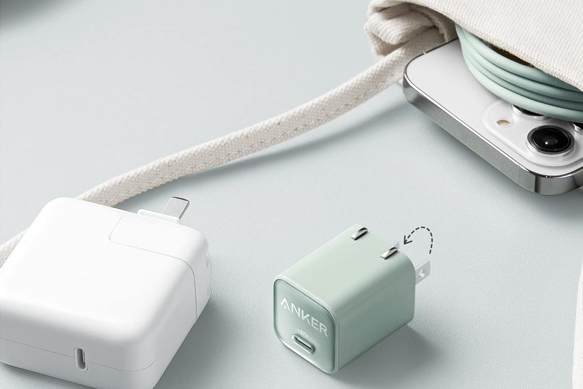 the anker nano charger sits beside a phone and purse