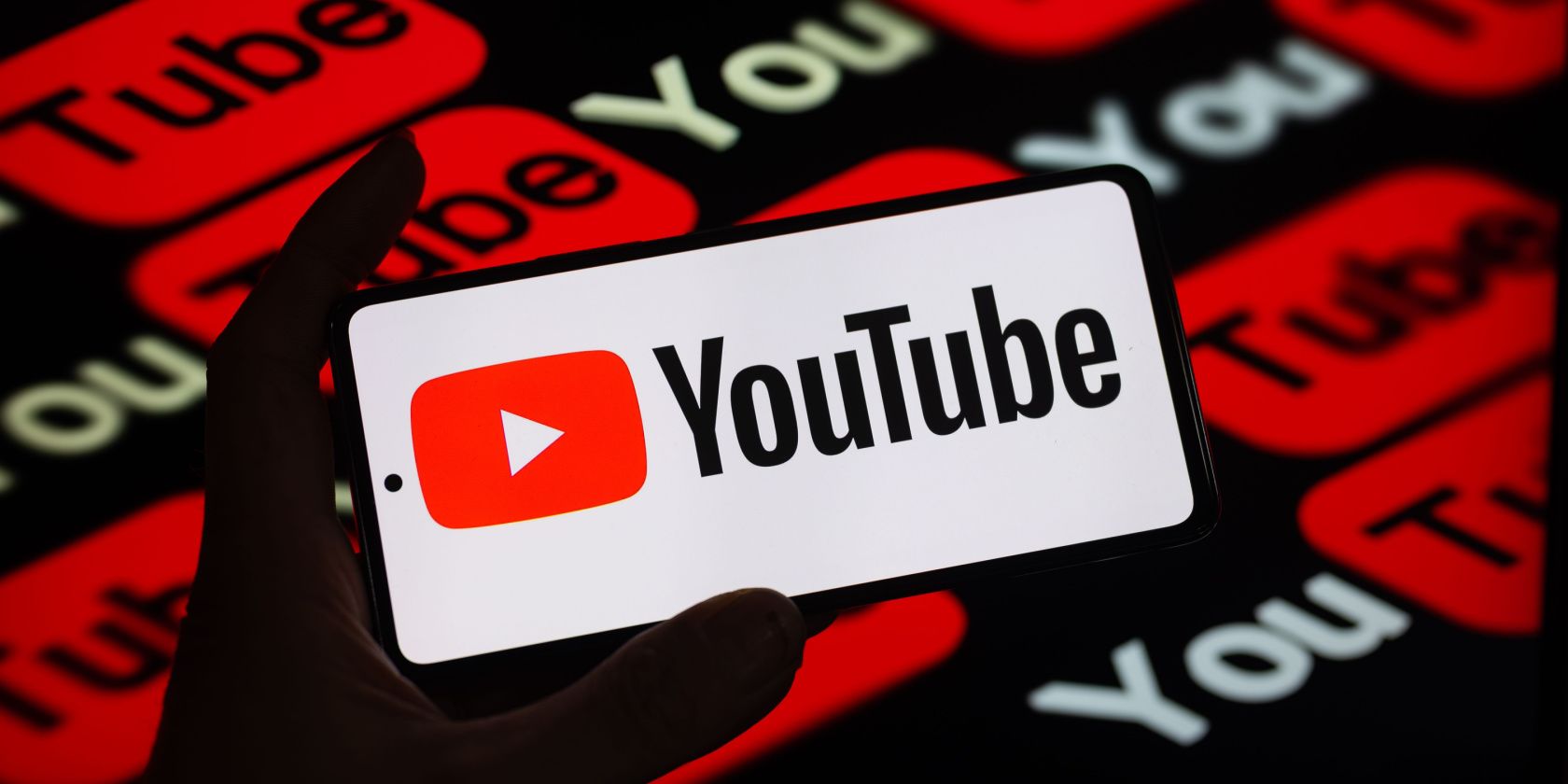 YouTube Logo on Smartphone Against YouTube Logos Background