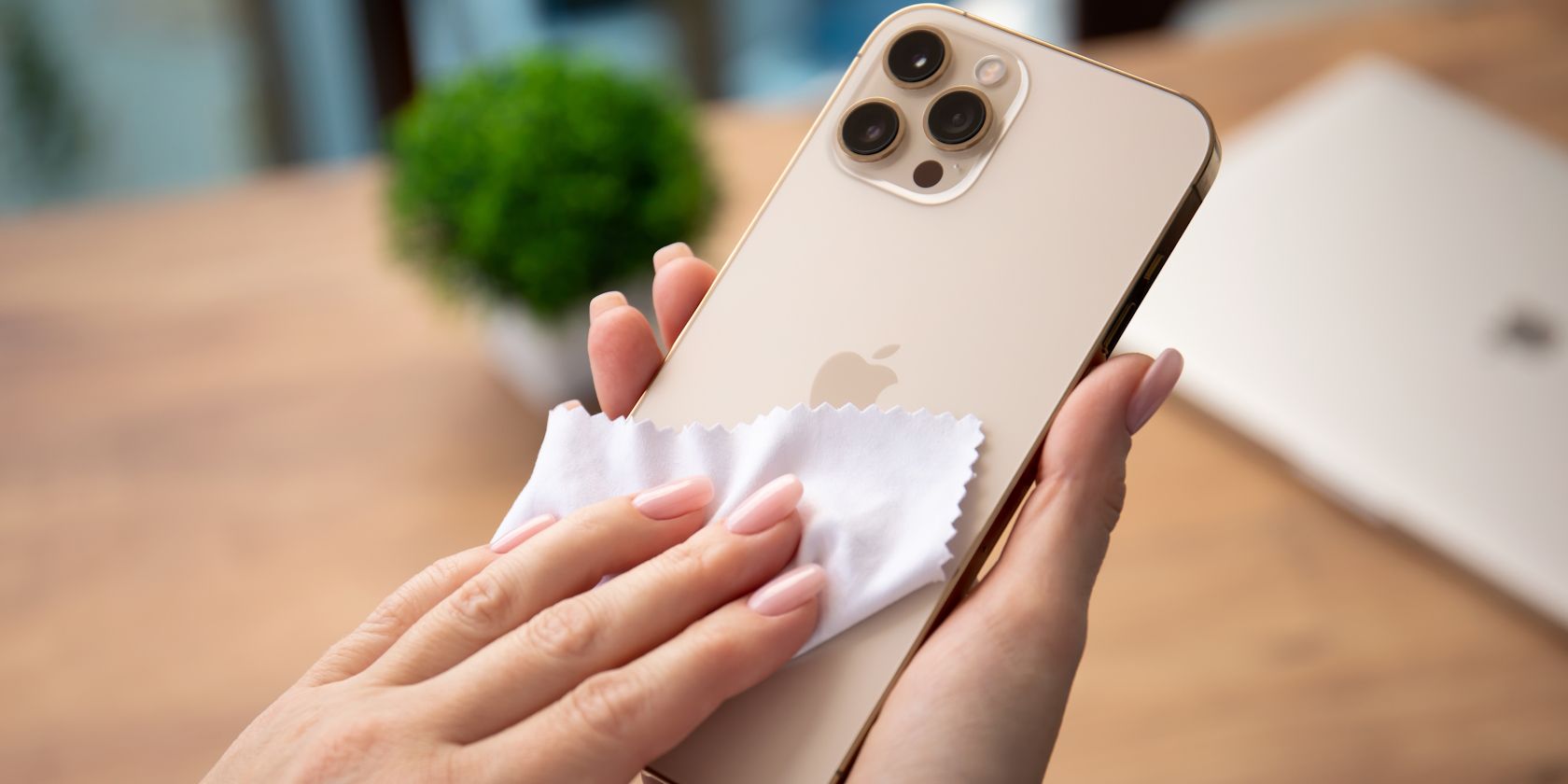 A woman cleaning an iPhone with a microfiber cloth