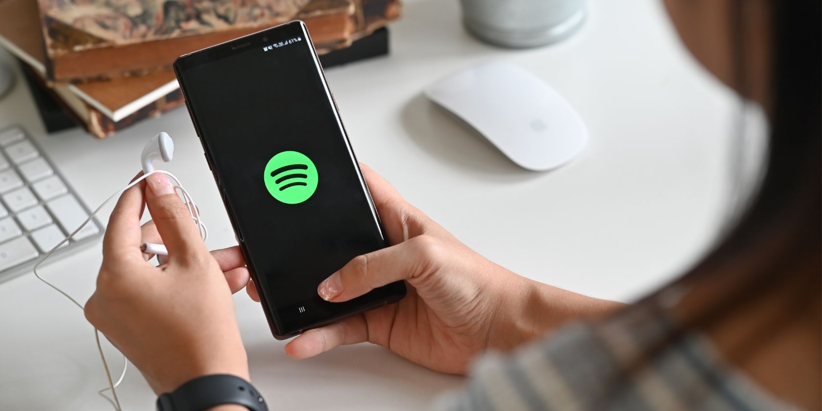 a woman holding a phone with the spotify logo