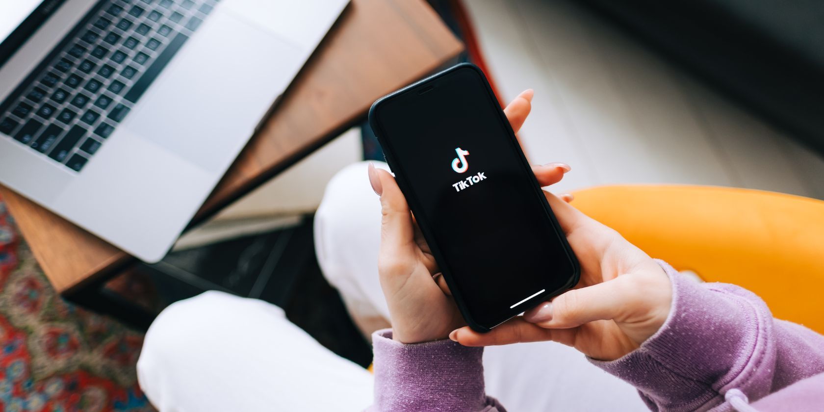 a woman holding a phone with the tiktok logo