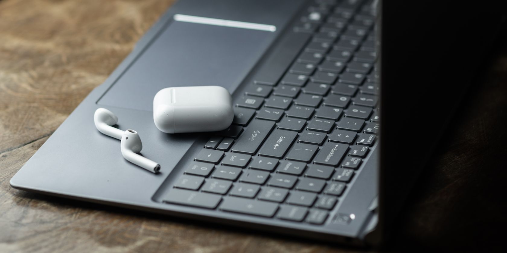 AirPods with case on top of a Windows laptop