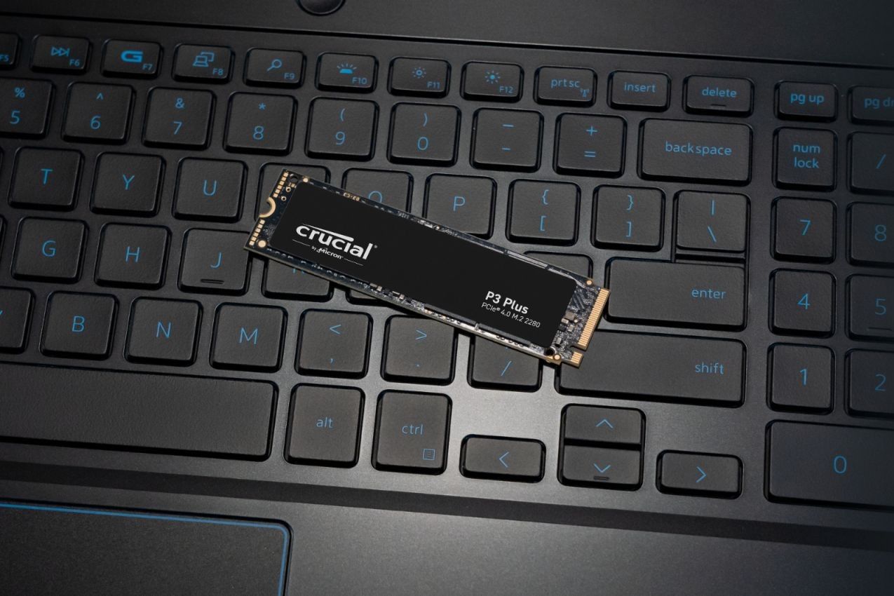 The Crucial P3 Plus NVMe SSD on a laptop's keyboard.