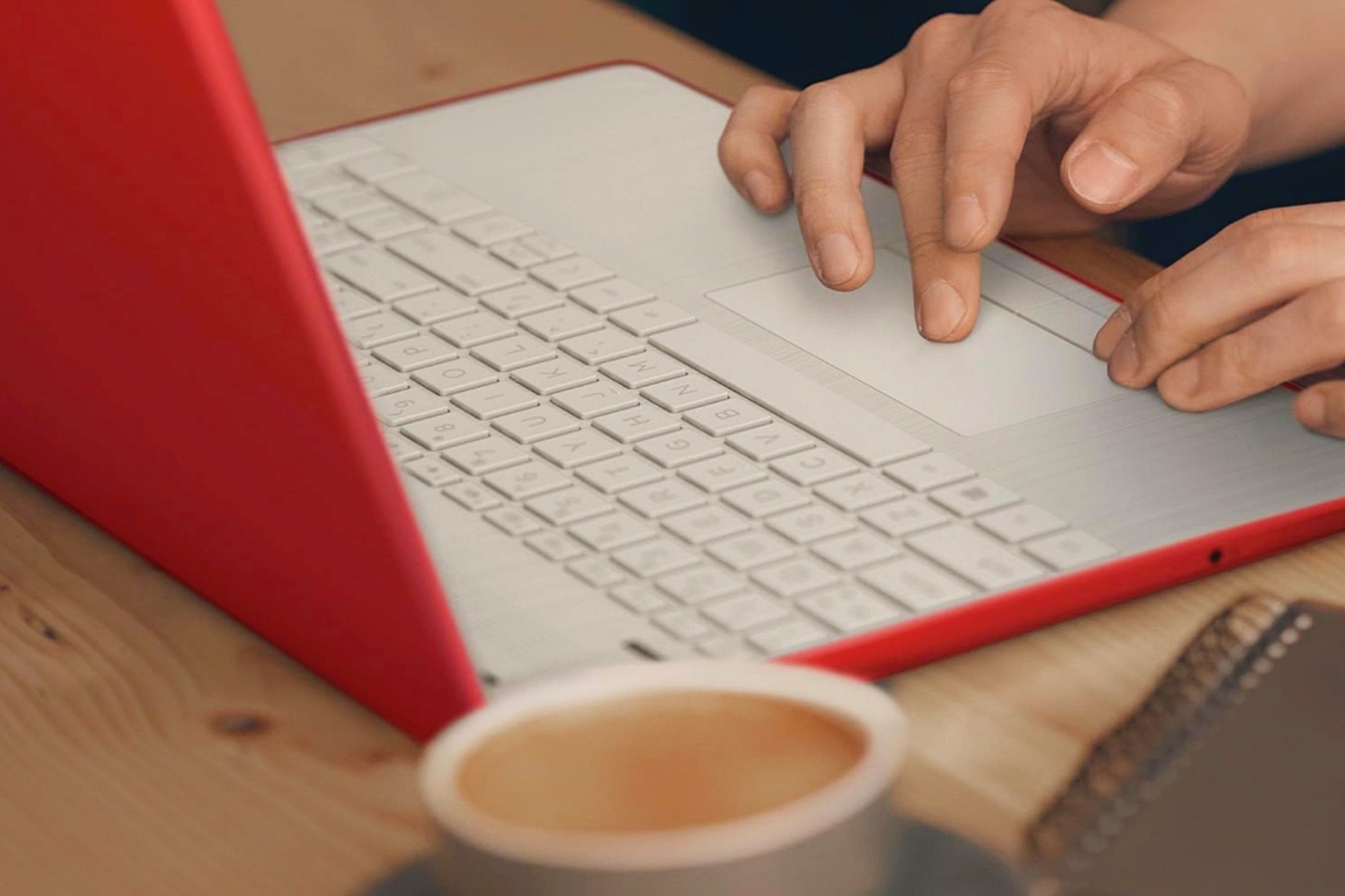 An image of a person's hands using the HP Pavilion 15.6-inch Laptop with a cup of coffee in the foreground.