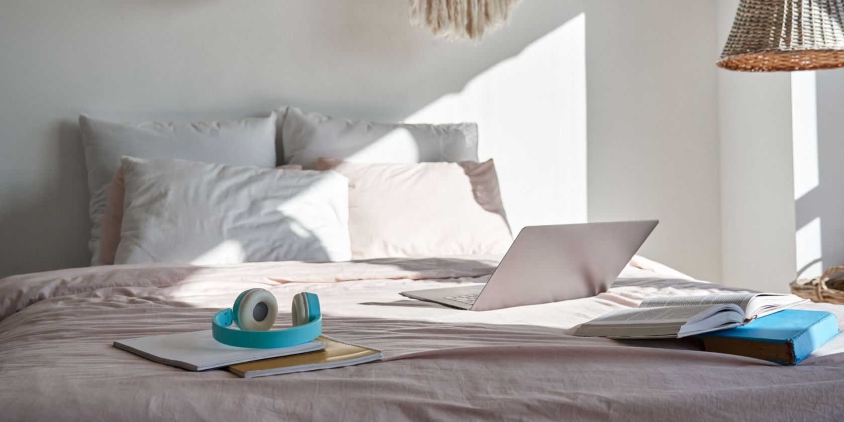 Laptop on Bed with headphones and books