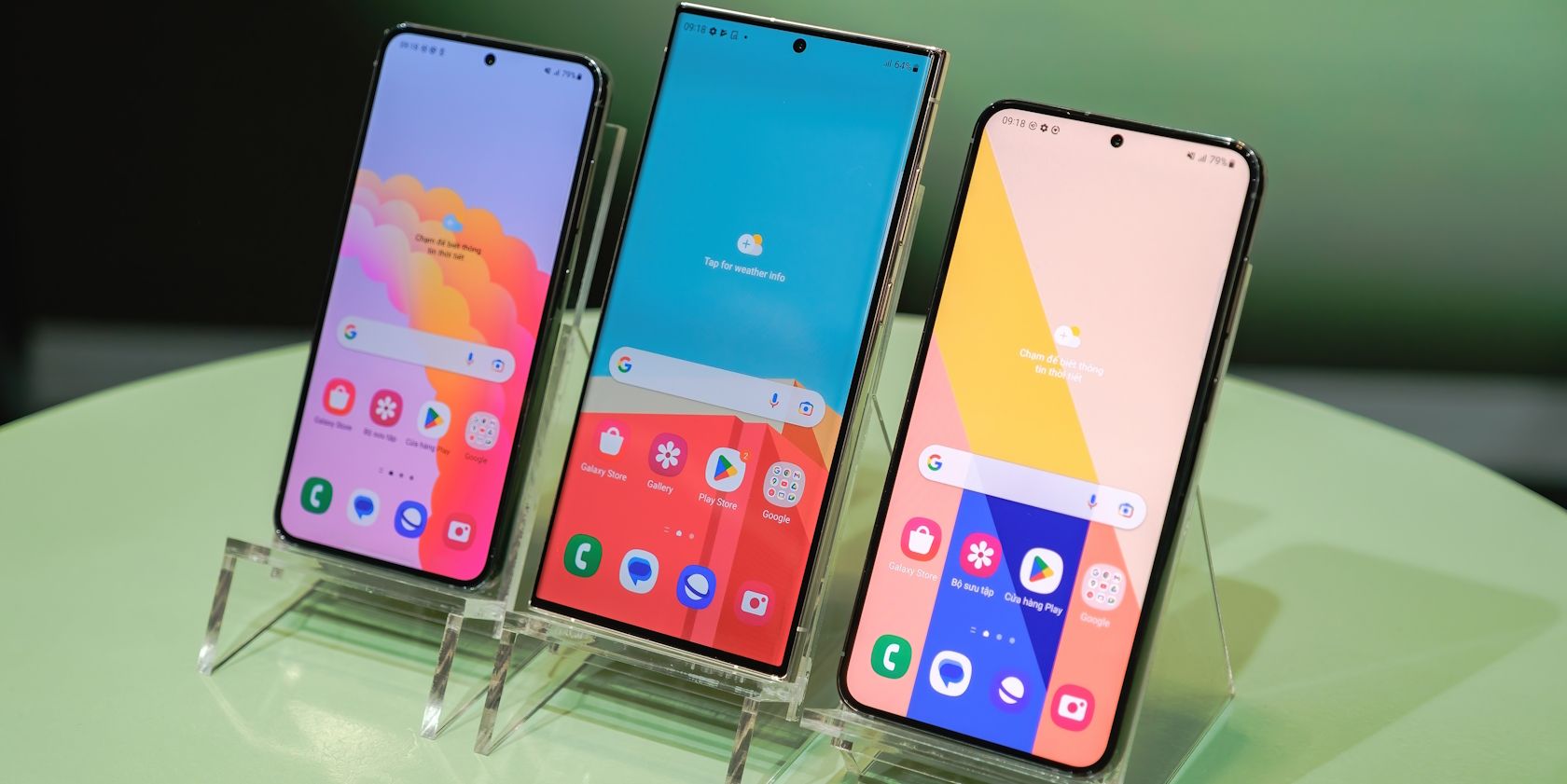 Three Samsung phones showcased on a table at a show
