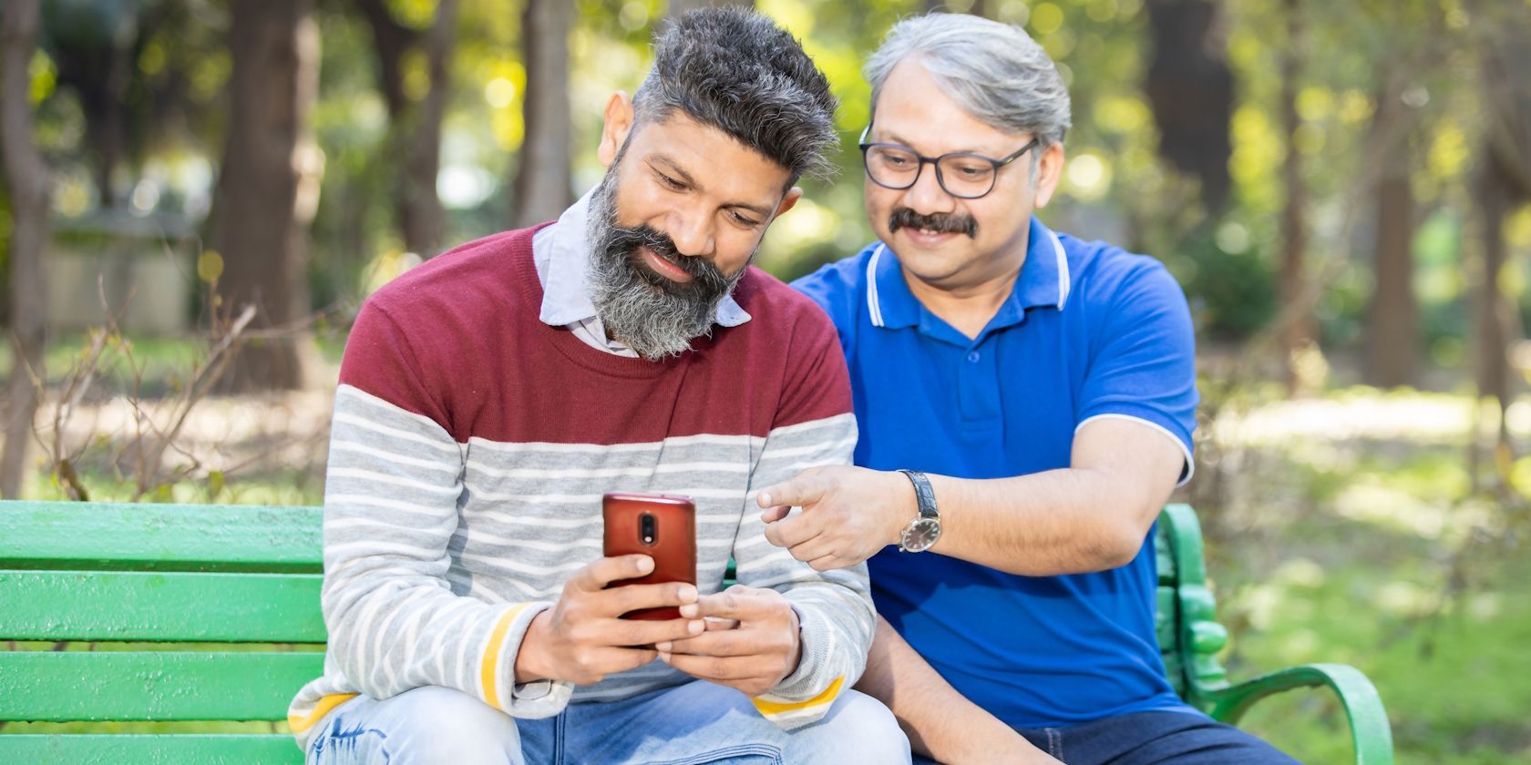 A middle-aged guy helping his dad use an Android phone
