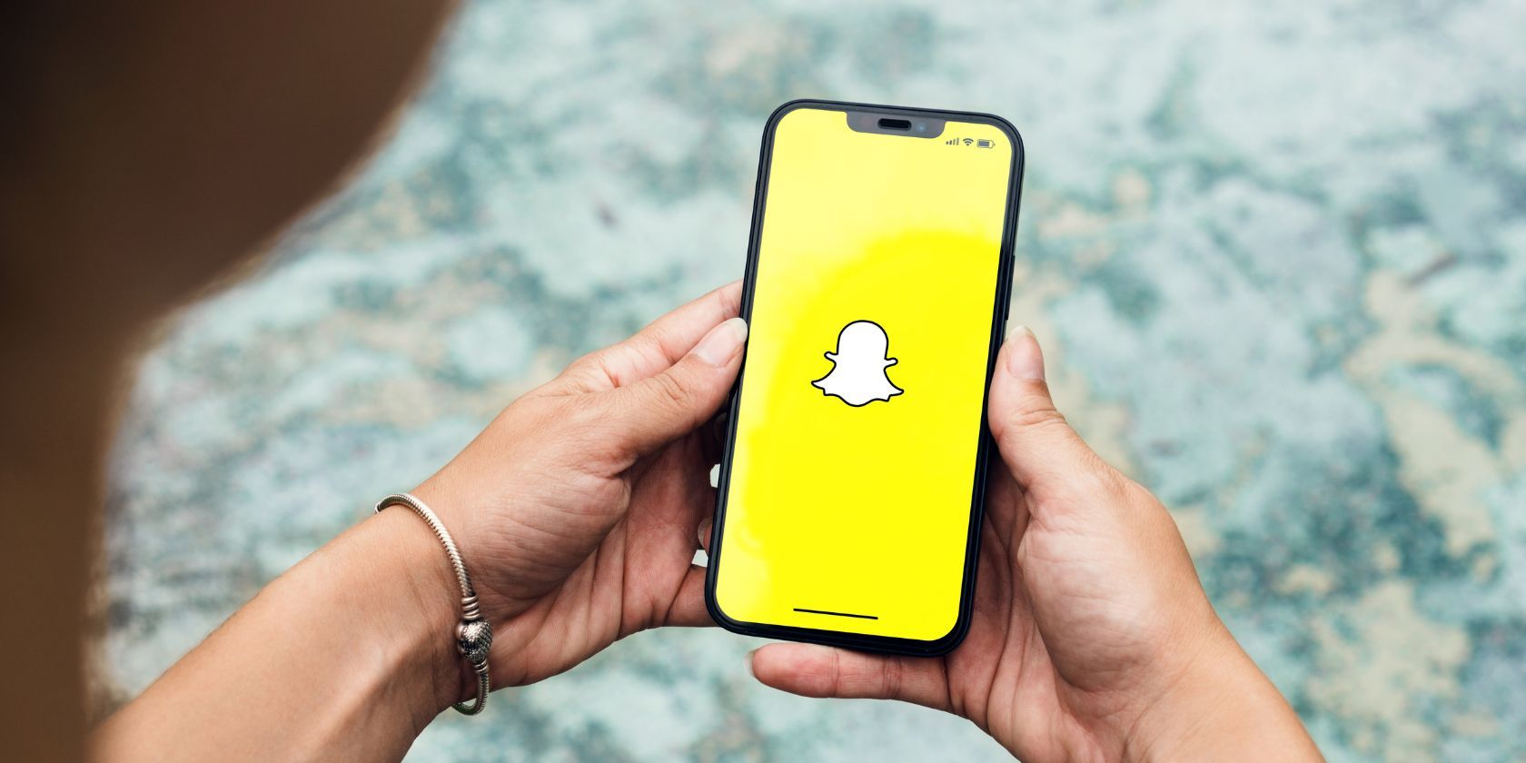 a person holding a phone with the snapchat logo