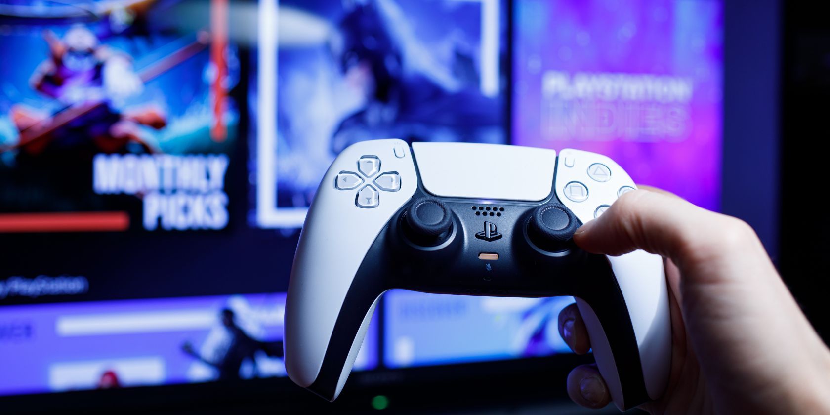 a ps5 controller in front of a tv screen