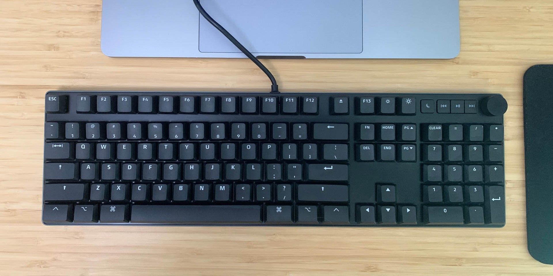 MacTigr keyboard on desk in front of MacBook Pro