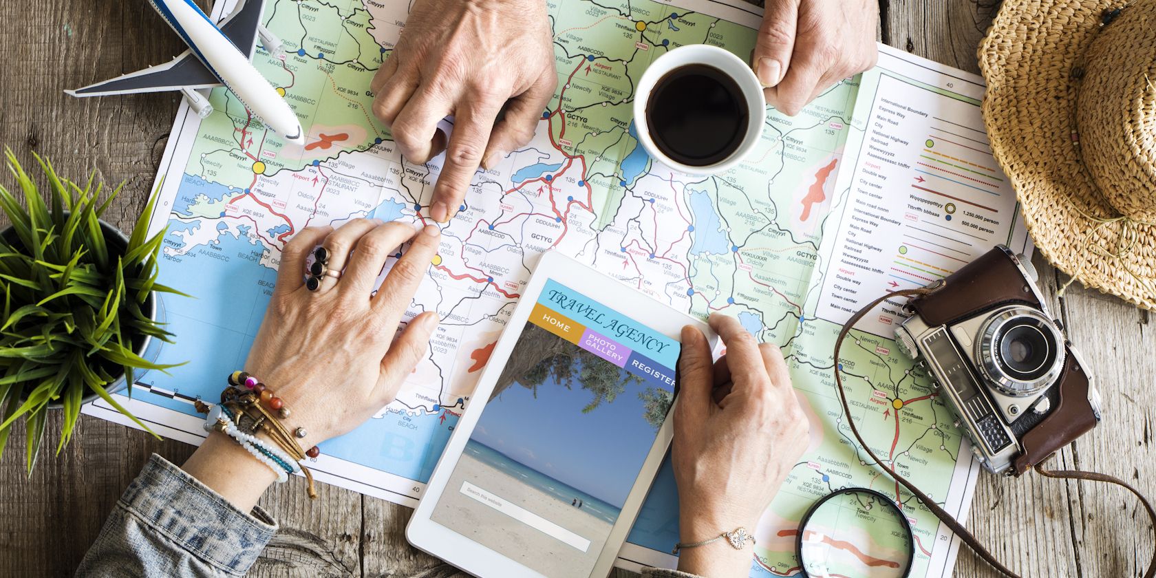 people planning a holiday using a map and tablet